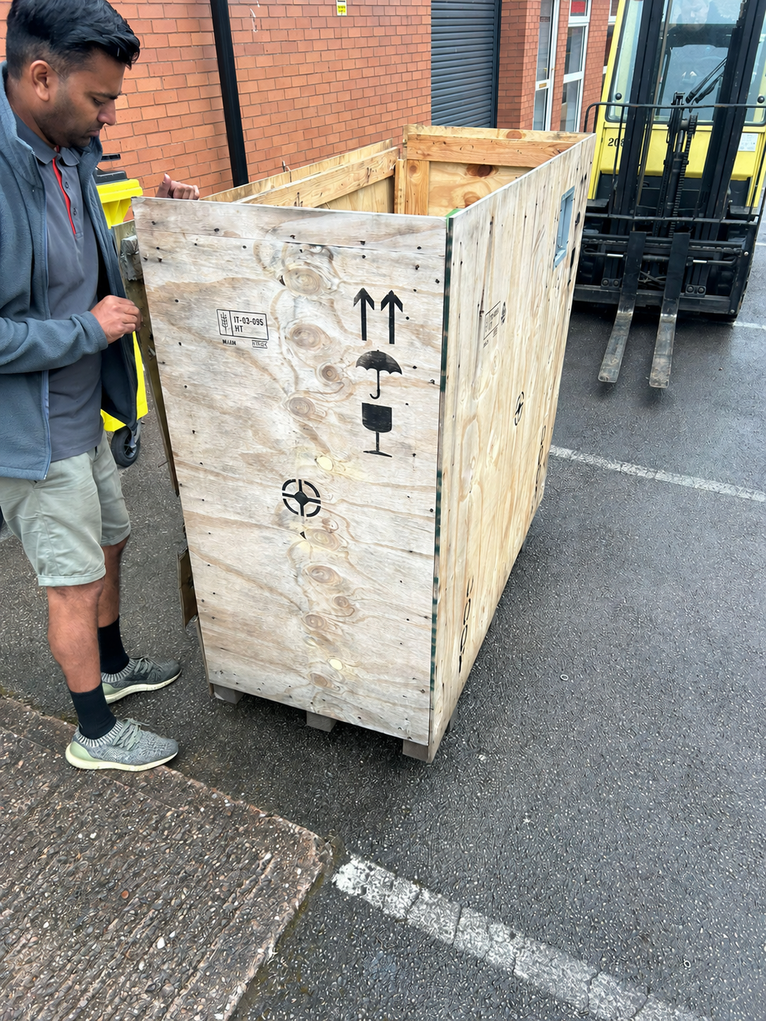 Real delivery photograph: crated equipment being handled